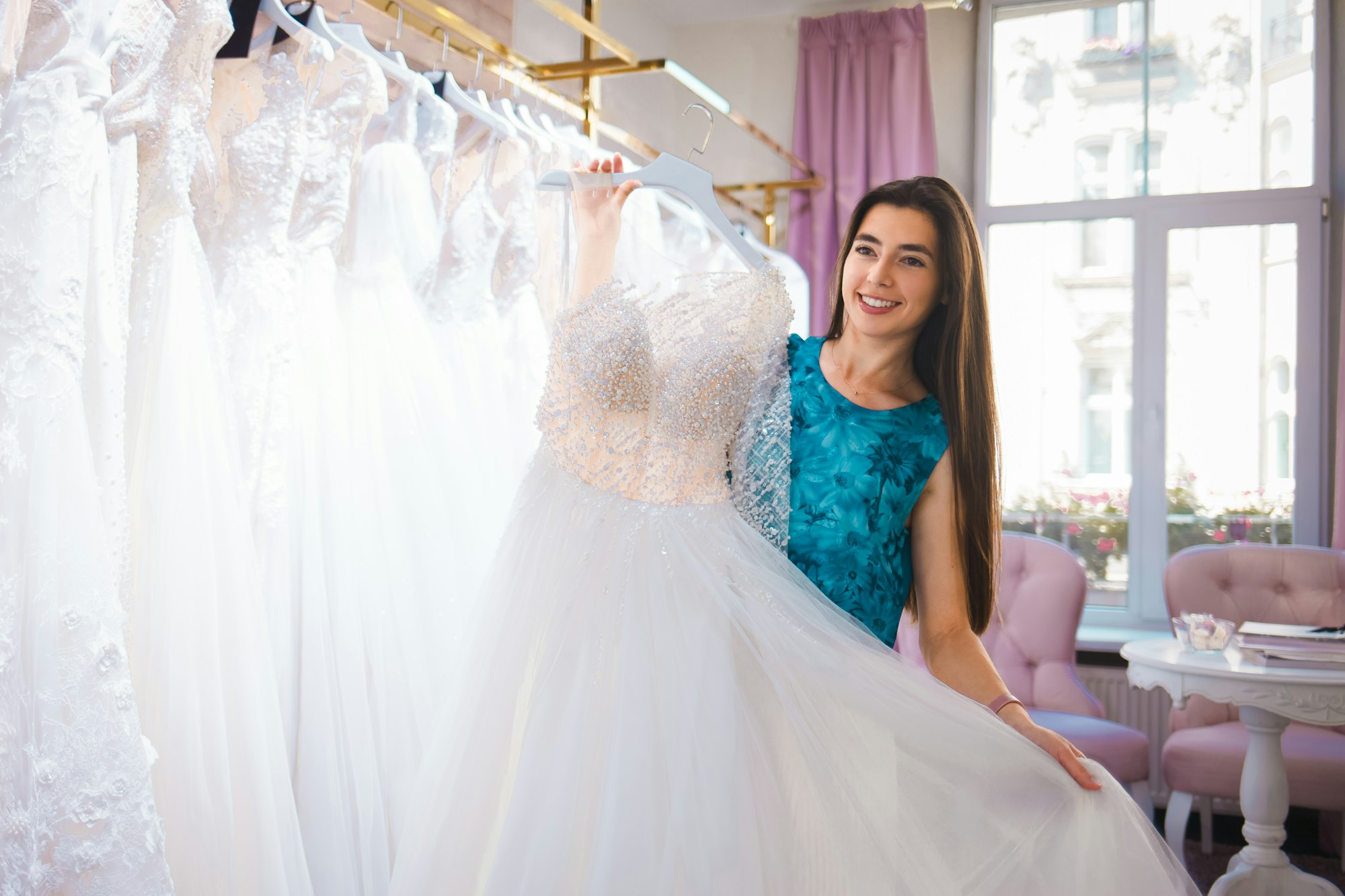 Happy bride chooses a dress in a wedding boutique